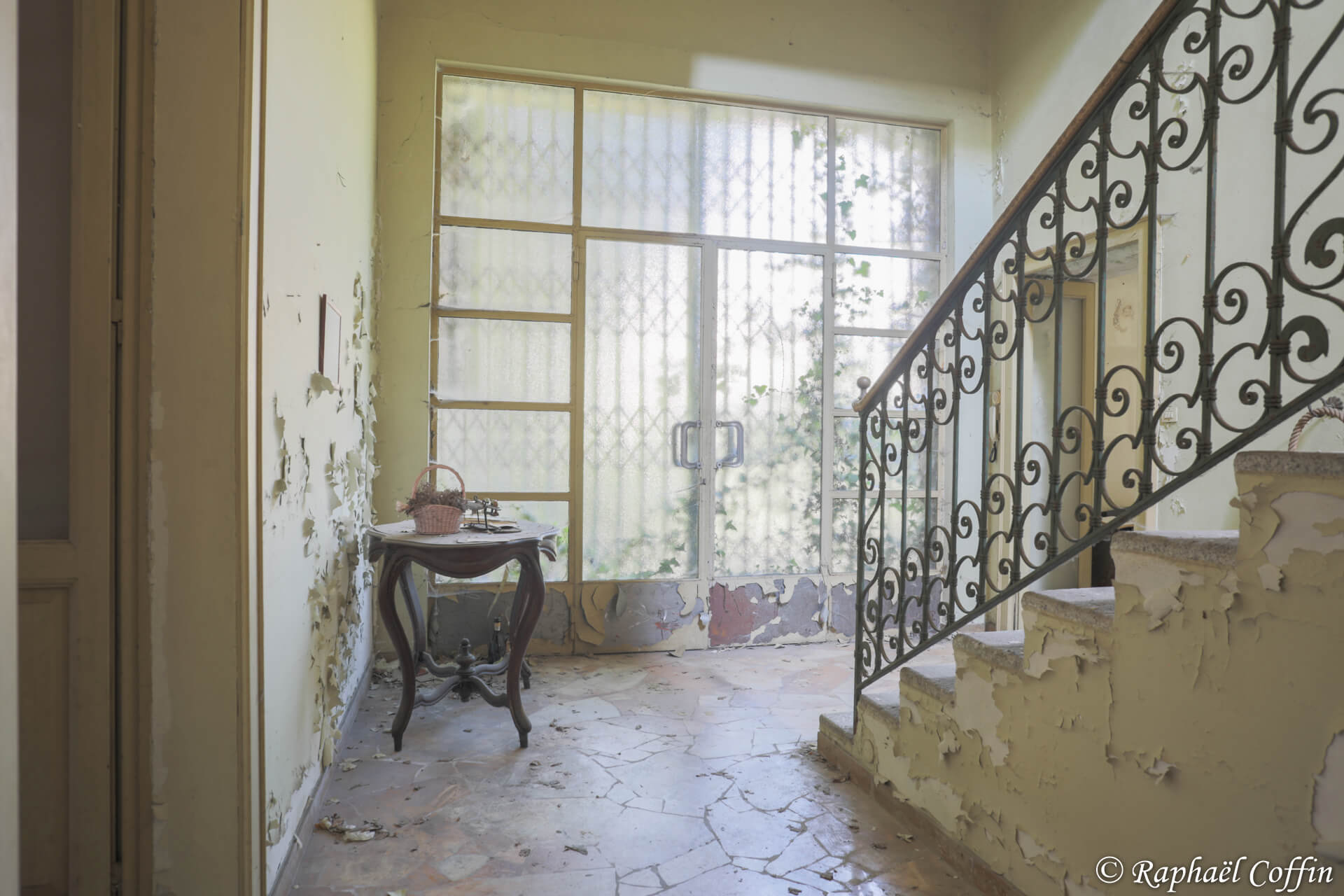 Porte menant à l'escalier principal de la villa, la peinture est écaillée partout.