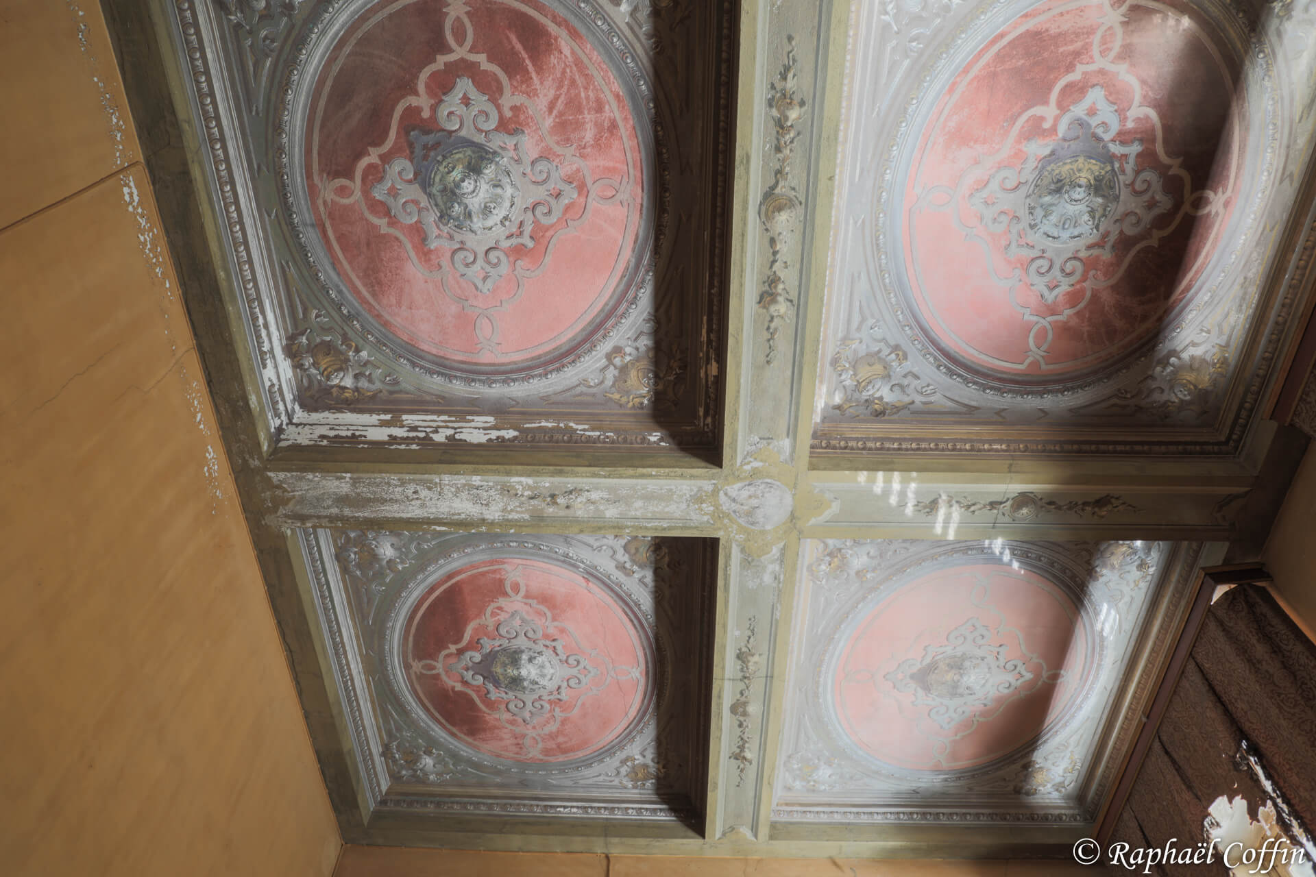 Plafond ouvragé en bois avec de la peinture rouge.